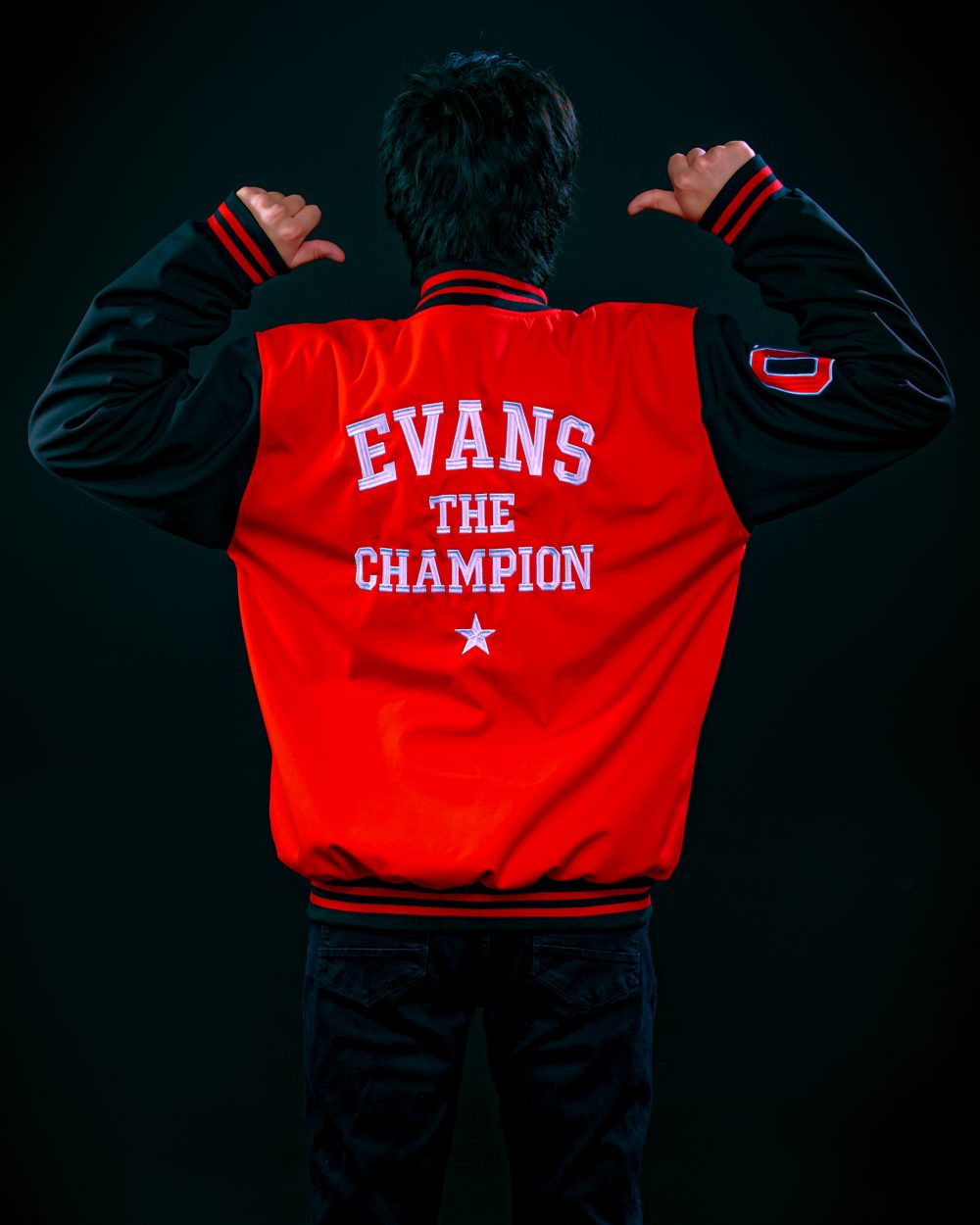 Evans The Champion de espaldas, mostrando el bordado de su chaqueta roja oficial.
